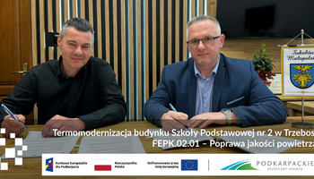 Burmistrz GiM Sokoł&oacute;w Małopolski Andrzej Kraska i Wojciech Leja (wykonawca) podpisują umowę przy stole w urzędzie w Sokołowie Małopolskim; na grafice napis: &bdquo;Termomodernizacja budynku Szkoły Podstawowej nr 2 w Trzebosi &ndash; FEPK.02.01 Poprawa jakości powietrza&rdquo; oraz logotypy Funduszy Europejskich i wojew&oacute;dztwa podkarpackiego.